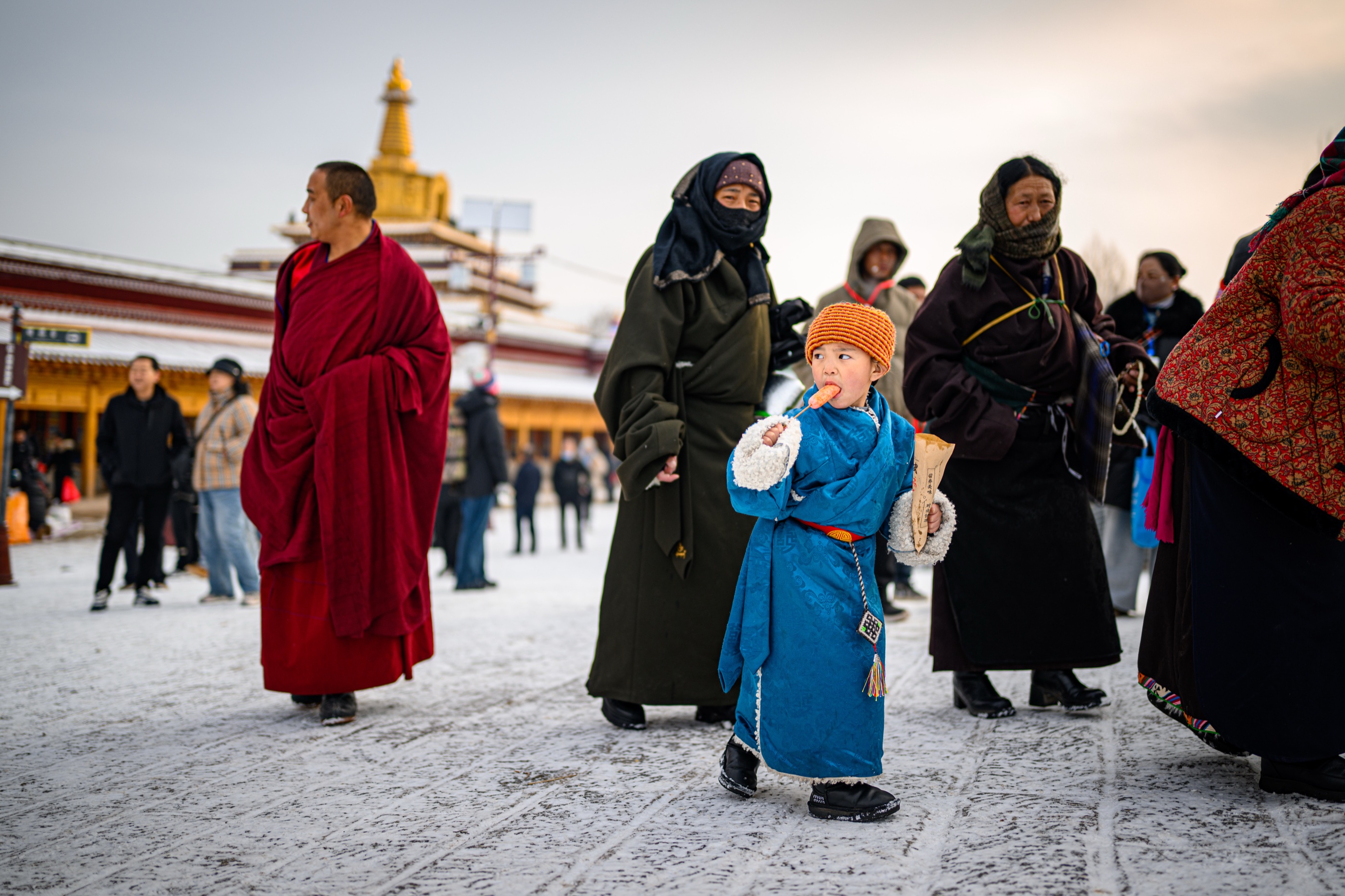 Monks and local residents walking across the snow